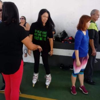  esquerda, de costas, est uma mulher de cabelos pretos at o ombro, camiseta preta e cala vermelha. Em segundo plano, v-se uma mulher sobre patins, de frente para a foto. Ela tem cabelos pretos at o ombro, usa camiseta da campanha da Bengala Verde do IPC, com os dizeres 