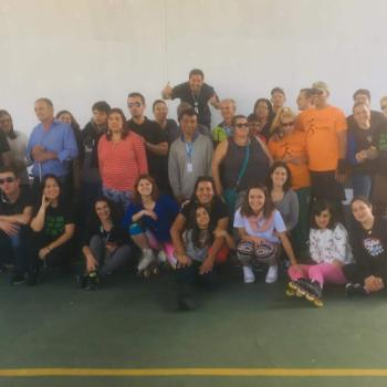 Foto de 34 pessoas, algumas em p, outras agachadas e sentadas, sorrindo.  a turma que participou da atividade de patins.