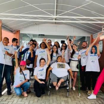 Fotografia colorida na frente da portaria do IPC. Estudantes, professores e funcionrios com a camiseta do projeto 