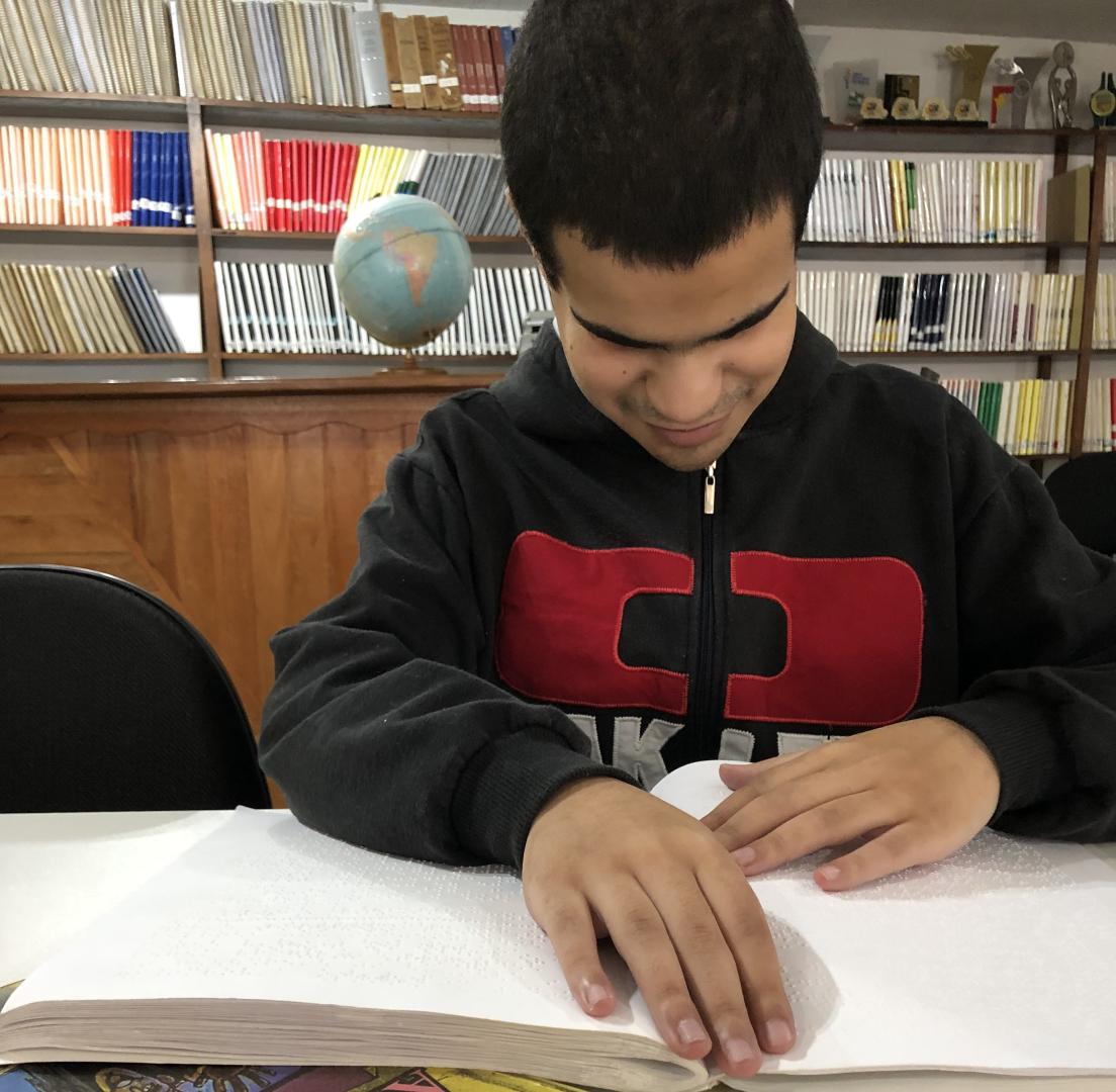 #PraTodosVerem Em uma biblioteca um jovem l&ecirc; um livro em braille sobre uma mesa. Ao fundo, livros em prateleiras.Celebrado em 4 de janeiro, o Dia Mundial do Braille marca o nascimento do franc&ecirc;s Louis Braille, em 1809. Cego desde a inf&acirc;ncia, ele desenvolveu ainda na adolesc&ecirc;ncia o sistema de leitura e escrita t&aacute;til que transformou o acesso &agrave; educa&ccedil;&atilde;o, &agrave; informa&ccedil;&atilde;o e &agrave; cidadania de pessoas cegas em todo o mundo. Mais de dois s&eacute;culos depois, em um cen&aacute;rio cada vez mais digital, o Sistema Braille segue sendo essencial para a alfabetiza&ccedil;&atilde;o e a autonomia de pessoas com defici&ecirc;ncia visual.  No Instituto Paranaense de Cegos (IPC), refer&ecirc;ncia no atendimento e na educa&ccedil;&atilde;o desse p&uacute;blico no Paran&aacute;, o ensino do Braille continua sendo uma ferramenta central no processo educacional. Para o professor de Braile, Lucas Cadmiel, o m&eacute;todo permanece indispens&aacute;vel, especialmente na alfabetiza&ccedil;&atilde;o de crian&ccedil;as cegas. 